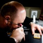 Zegarmistrz z lupą dokładnie ogląda mechanizm luksusowego zegarka